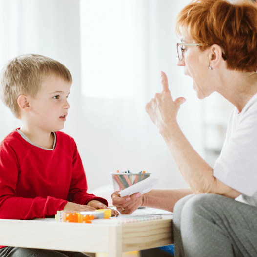 CHIRYO Outcomes and Intervention Services female staff speech and language and boy child sat learning