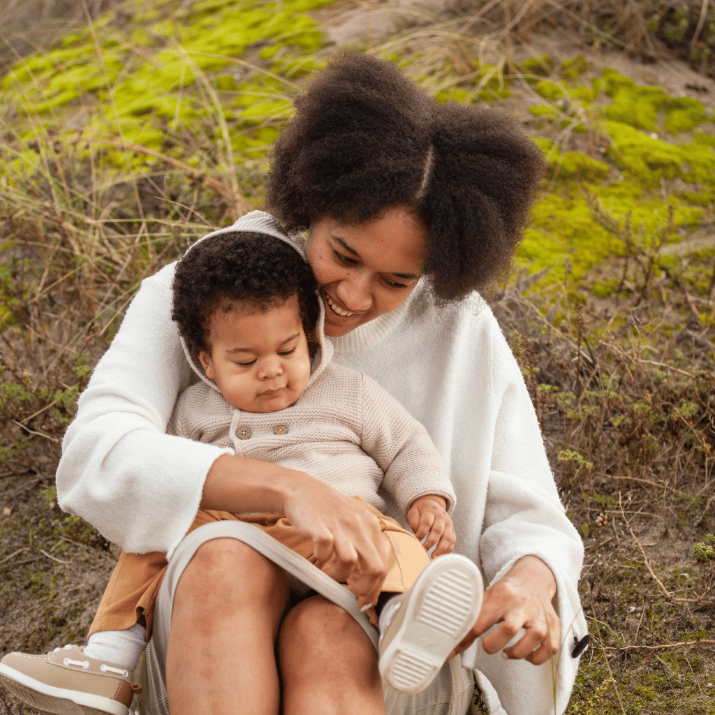 CHIRYO Outcomes and Intervention Services sat on grass with son on lap
